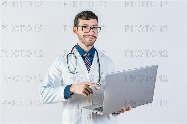 Smiling doctor using and pointing laptop isolated