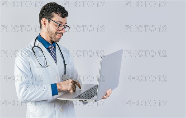 Handsome doctor using laptop isolated