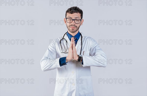 Doctor praying with hands together on isolated background