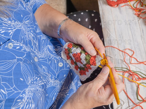 Top close-up view of a woman's crocheting hands