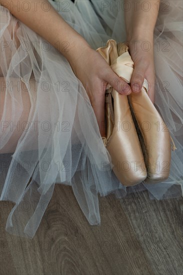 Legs of girl dancing ballet with tulle skirt and pink shoes different dance steps wooden floor and white background with copy space