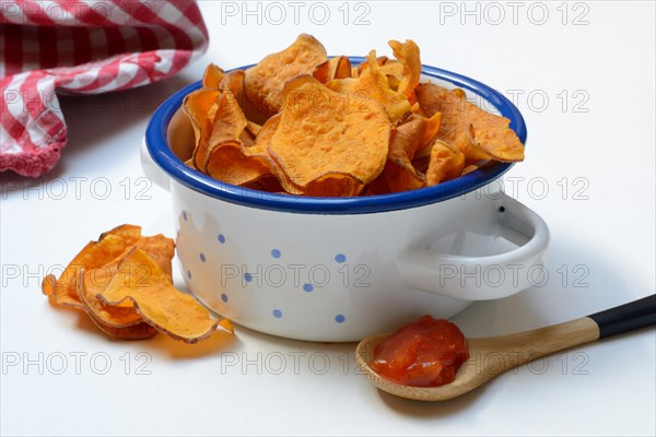 Sweet crisps and salsa sauce in wooden spoon