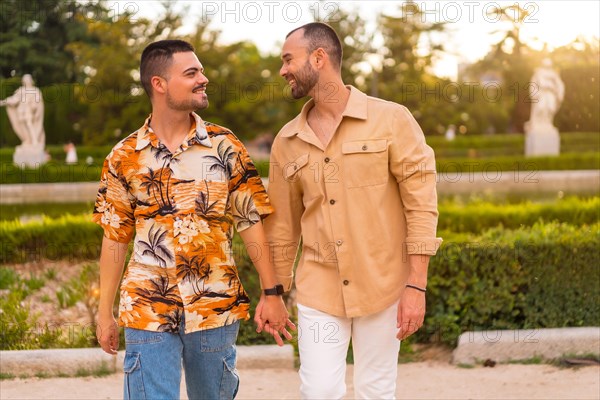 Romantic portrait of gay newlyweds walking in the sunset in a park in the city