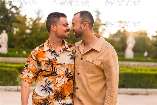 Romantic portrait of gay newlyweds walking and having fun at sunset in a park in the city