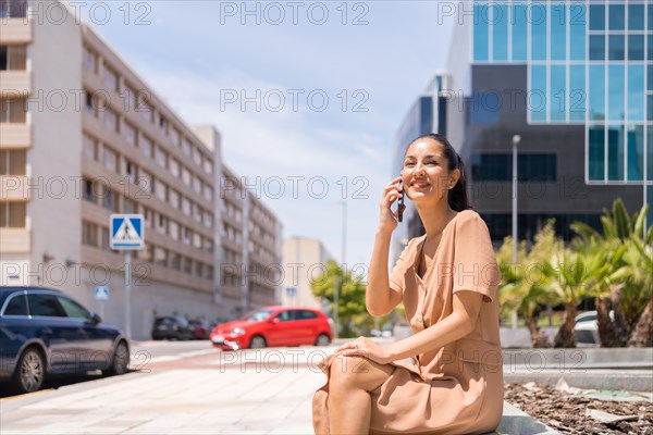 Portrait of a Latin woman executive or businesswoman in a business office area talking on the phone