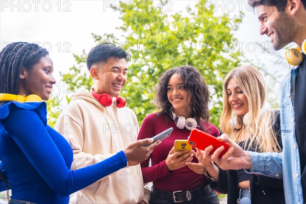 A group of young multi-ethnic teenage friends using cell phones in the city campus