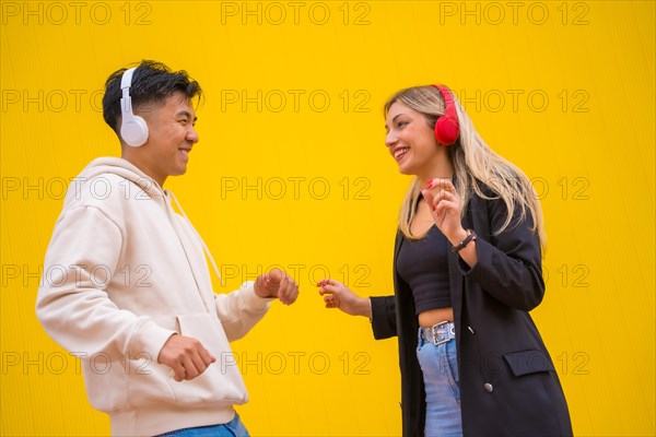 Multiethnic couple of Asian man and Caucasian woman on a yellow background