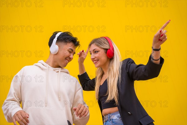 Multiethnic couple of Asian man and Caucasian woman on a yellow background