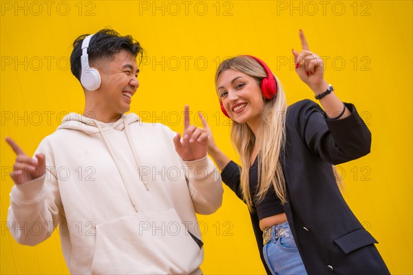 Multiethnic couple of Asian man and Caucasian woman on a yellow background