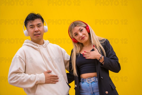 Portrait of multiethnic couple of Asian man and Caucasian woman on a yellow background