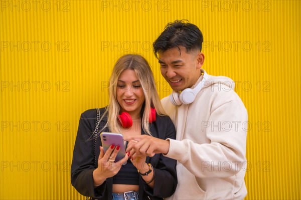 Portrait of multiethnic couple of Asian man and Caucasian woman on a yellow background