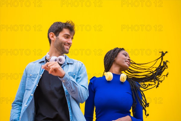 Multiethnic wedding couple of Caucasian man and woman of black ethnicity on a yellow background