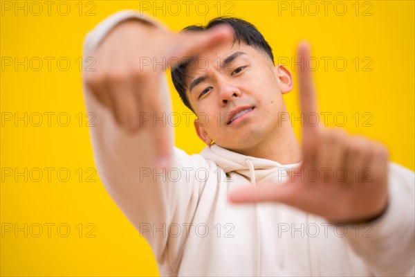 Portrait of a south korean man in basic clothes over yellow background