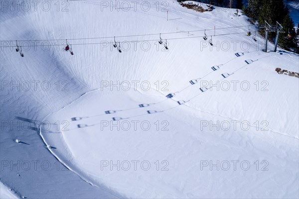 A chairlift casts its shadow over the reservoir in the Brauneck ski area