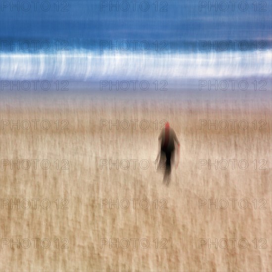 Woman walking across the beach to the sea