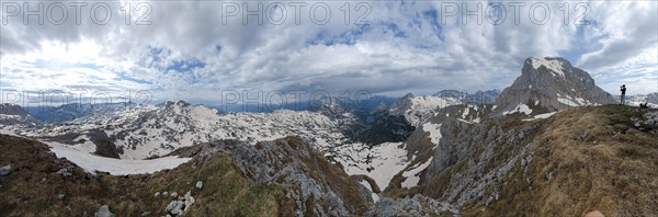 A hiker photographs the mountains of the Steinernes Meer in spring