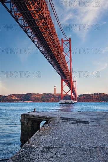 View from under of 25 de Abril Bridge famous tourist landmark over Tagus river