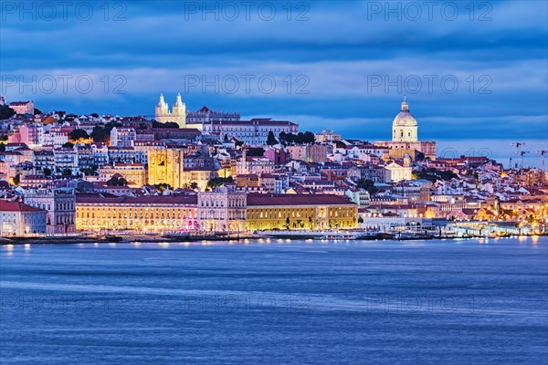 View of Lisbon over Tagus river with ferry boats in evening twilight
