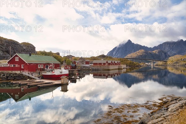 Rorbuer and high mountains reflected in a fjord