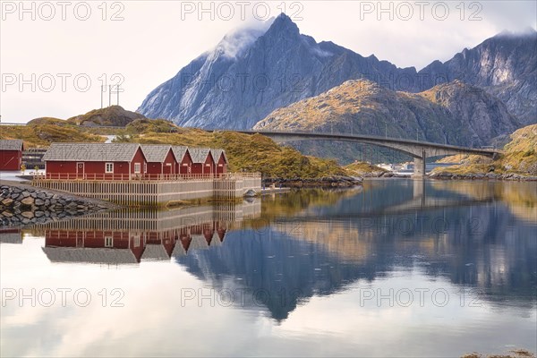 Rorbuer and high mountains reflected in a fjord