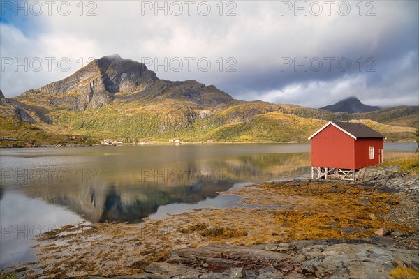 Rorbuer and high mountains reflected in a fjord