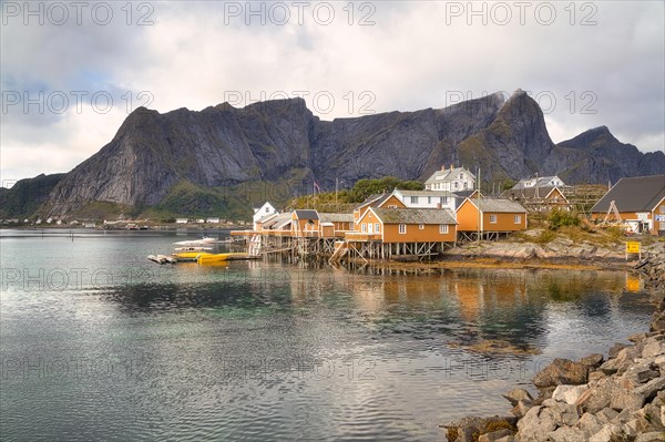 Yellow rorbu houses on a stony shore