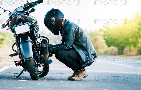 Biker repairing motorcycle on the road