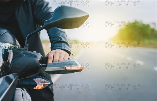 Hands of a motorcyclist on the handlebars on the road
