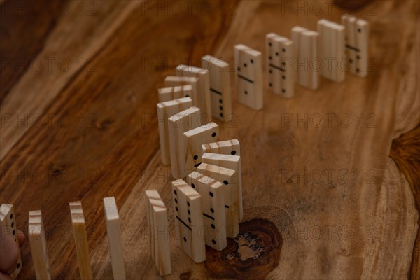 Wooden dominoes in a row on a wooden table