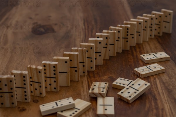 Wooden dominoes in a row on a wooden table