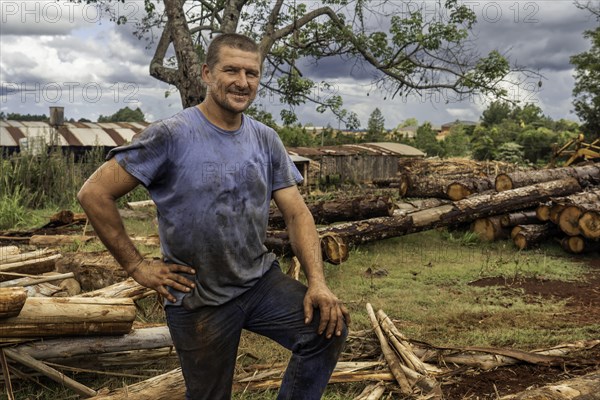 Mature male professional forester standing in sawmill looking at camera