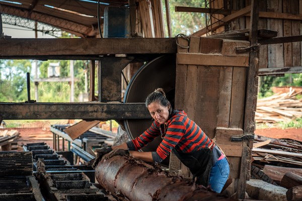 Female worker in work uniform in a sawmill