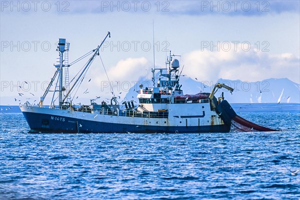 Russian Shrimp trawlers fishing in arctic waters outside a rocky coast