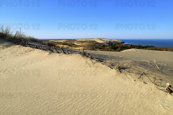 View of diagonal nordic dune edge with submerged protective fences