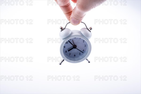 Alarm clock in hand on a white background