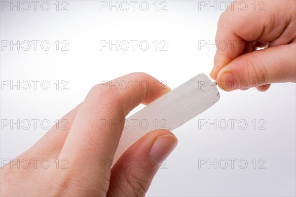 White candle stick in hand on a white background