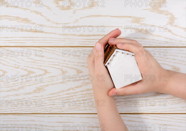 Little model housein hand on a parquet background