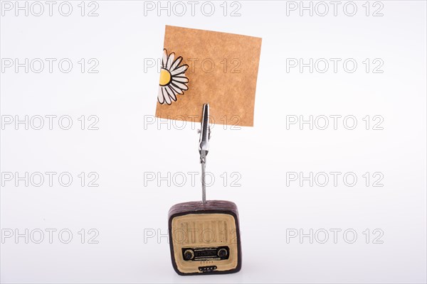 Note paper attached to an retro styled radio on a white background