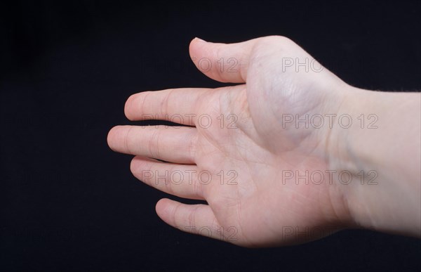 Five fingers of a child hand partly seen in black background