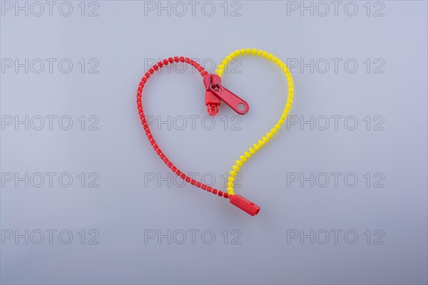 Heart shaped made by the help of a zipper on white background