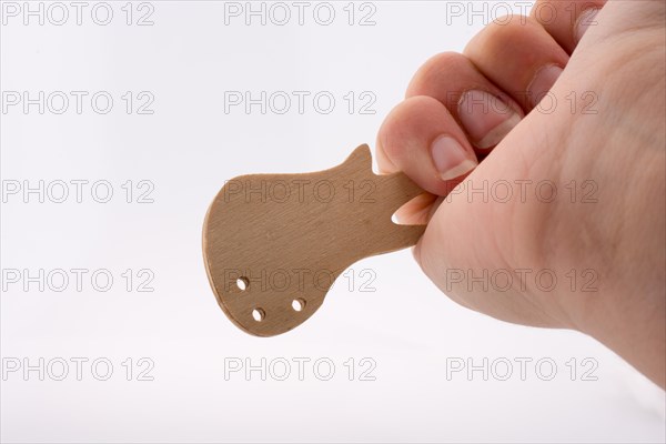 Mini wooden guitar model in hand on a white background