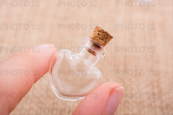 Heart shaped glass bottle is held in hand
