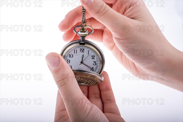 Hand holding a retro styled pocket watch in hand