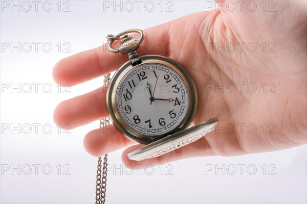 Hand holding a retro styled pocket watch in hand