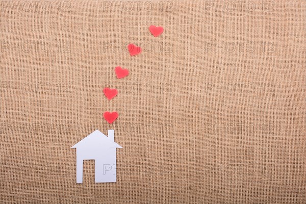 Heart shape coming out of chimney of paper house