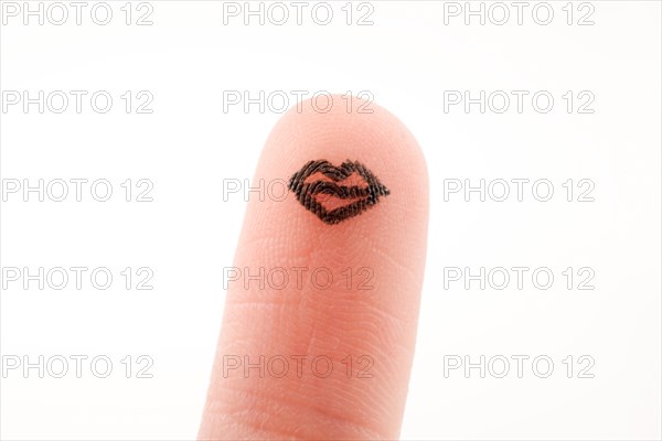 Lips drawn on a finger tip with black color