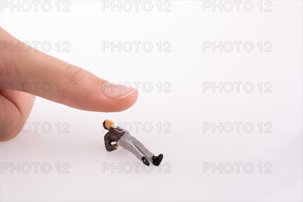 Hand threating to smash human figure on a white background