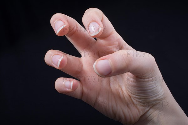 Five fingers of a child hand partly seen in black background