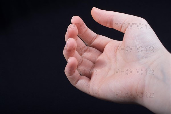 Five fingers of a child hand partly seen in black background