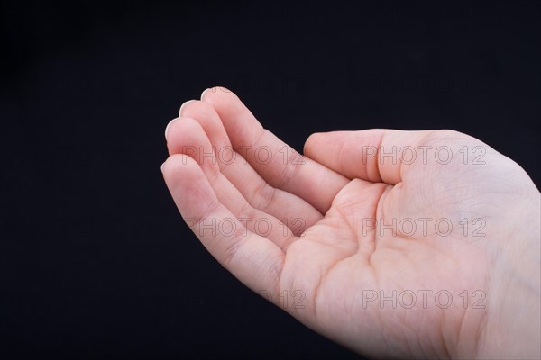 Five fingers of a child hand partly seen in black background